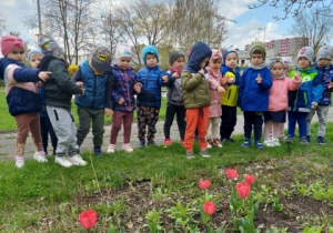 Dzieci podziwiają tulipany zasadzone wiosną